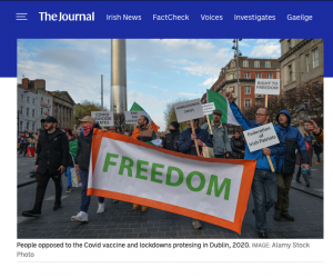 Screenshot from the journal picture of anti lockdown protesters from 2021 marching in Dublin behind a "freedom" banner.